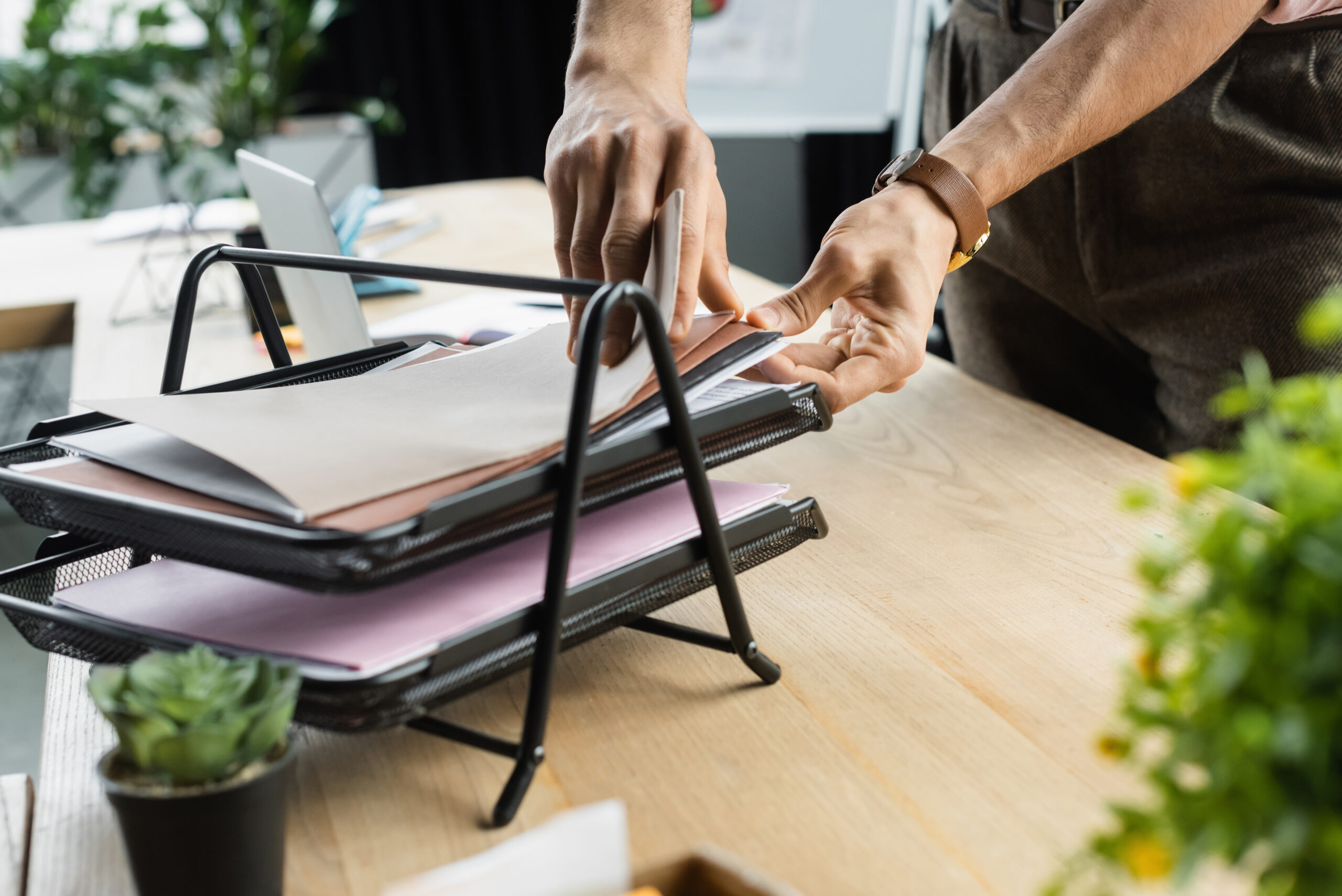 Cropped view of manager searching papers on table in office